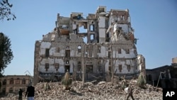 Houthi Shiite rebels walk amid the rubble of the Republican Palace that was destroyed by Saudi-led airstrikes, in Sanaa, Yemen, Dec. 6, 2017.
