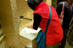 In this Monday, Feb. 3, 2020, photo taken by the passenger, another passengers wash their hands on the cruise ship Diamond Princess anchored off Yokohama, south of Tokyo. (@daxa_tw via AP)