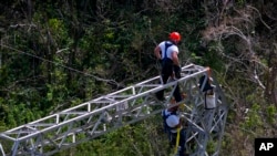 FILE - Whitefish Energy Holdings workers restore power lines damaged by Hurricane Maria in Barceloneta, Puerto Rico, Oct. 15, 2017.