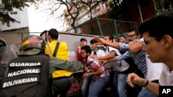 Los funcionarios venezolanos de la guardia nacional bolivariana se enfrentan a estudiantes universitarios durante una protesta fuera del Tribunal Supremo en Caracas, Venezuela, el viernes 31 de marzo de 2017.