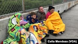 Migrants from Venezuela, Cuba and Guatemala wait at bridge between Matamoros, Mexico and Brownsville, Texas for immigration officials to allow them to turn themselves in and ask for asylum in US, Nov. 12, 2018.