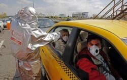 IRAN -- Members of Iranian Red Crescent test people with possible coronavirus Covid-19 symptoms, as police blocked Tehran to Alborz highway to check every car following ordered by the Iranian government, outside Tehran, March 26, 2020