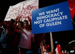 FILE - Supporters of Turkish President Recep Tayyip Erdogan hold a placard during a pro-government rally at Kizilay main square, in Ankara, Turkey, July 20, 2016.