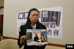 李明哲的妻子李净瑜向媒体展示李明哲以往活动的照片(2017年3月28日 美国之音杨明拍摄)