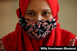 Seorang perempuan mengenakan masker batik tradisional Indonesia di sebuah bengkel di Jakarta, 1 Juli 2020. (Foto: REUTERS/Willy Kurniawan)