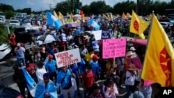 Manifestantes llevan carteles durante la protesta pacífica contra el entonces proyecto de ley 1718 del Senado de Florida, el jueves 1 de junio de 2023, en Immokalee, Florida.