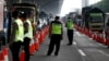 Petugas polisi mengenakan masker berjaga di pos pemeriksaan jalan raya di Bekasi, menyusul larangan mudik lebaran untuk mencegah penyebaran virus corona (COVID-19), 24 April 2020. (Foto: Willy Kurniawan/Reuters/dok) 
