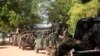 South Sudan army soldiers hold their weapons as they ride on a truck in Bor, Dec. 25, 2013. 