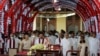 Preside Gotabaya Rajapaksa (depan,tiga dari kanan) dan PM Mahinda Rajapaksa (depan, tiga dari kiri) bersama para menteri kabinet baru menyanyikan lagu kebangsaan dalam upacara pelantikan kabinet di Kuil Buddha Gigi di ibukota bukit kuno Kandy, 116 km dari Kolombo,12 Agustus 2020.