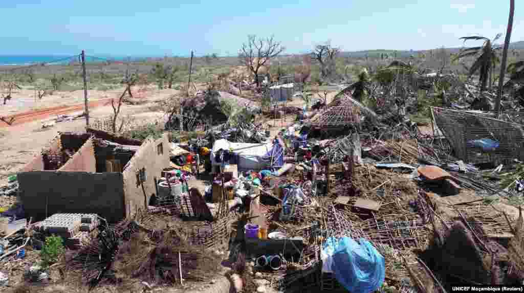 Pessoas no meio de edifícios destruídos, árvores desenraizadas e destroços após o ciclone Chido ter atingido o distrito de Mecufi, província de Cabo Delgado, Moçambique, a 16 de dezembro de 2024, nesta captura de ecrã retirada de um vídeo de um drone.