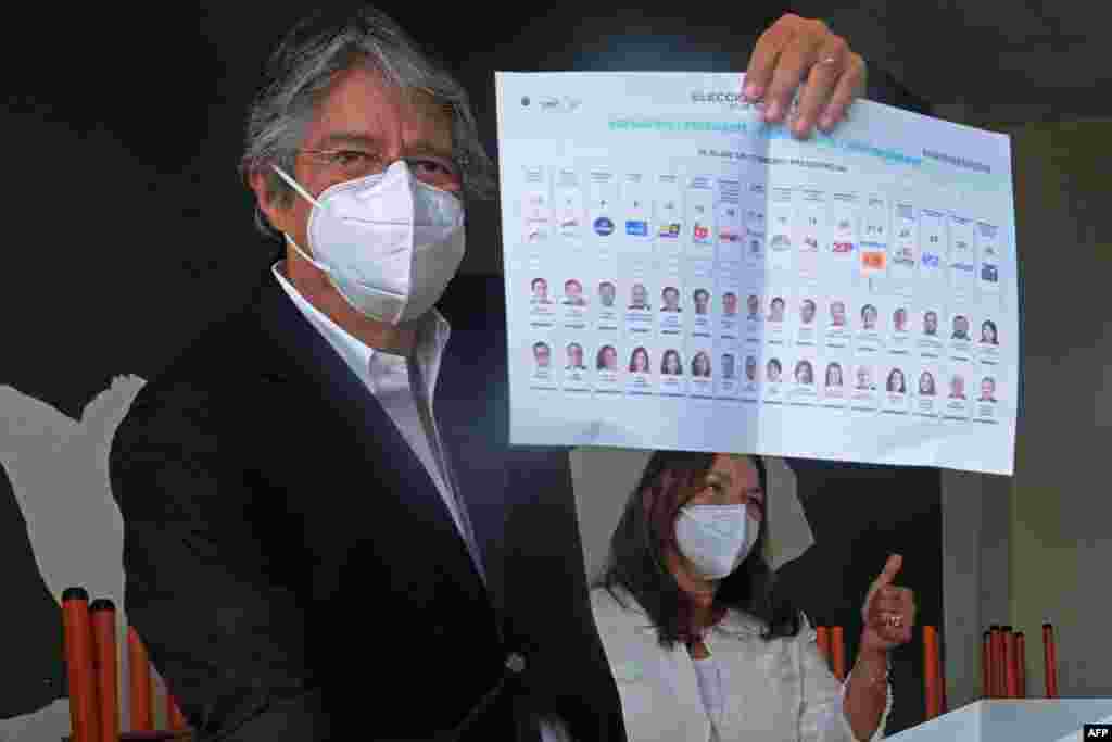 El candidato presidencial ecuatoriano Guillermo Lasso, acompañado de su esposa María de Lourdes Alcivar, muestra su voto en la Unidad Educativa Ileana Espine, durante las elecciones generales, en Cuenca, Ecuador, el 7 de febrero de 2021.
