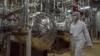 ARCHIVO - Un agente de seguridad iraní con ropa protectora recorre parte de la Planta de Conversión de Uranio, a las afueras de la ciudad iraní de Isfahán. 