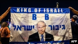 Right-wing demonstrators hold a banner showing an image of Israel's Prime Minister Benjamin Netanyahu during a rally in support of his government's planned judicial overhaul outside the Supreme Court in Jerusalem on Sept. 7, 2023.