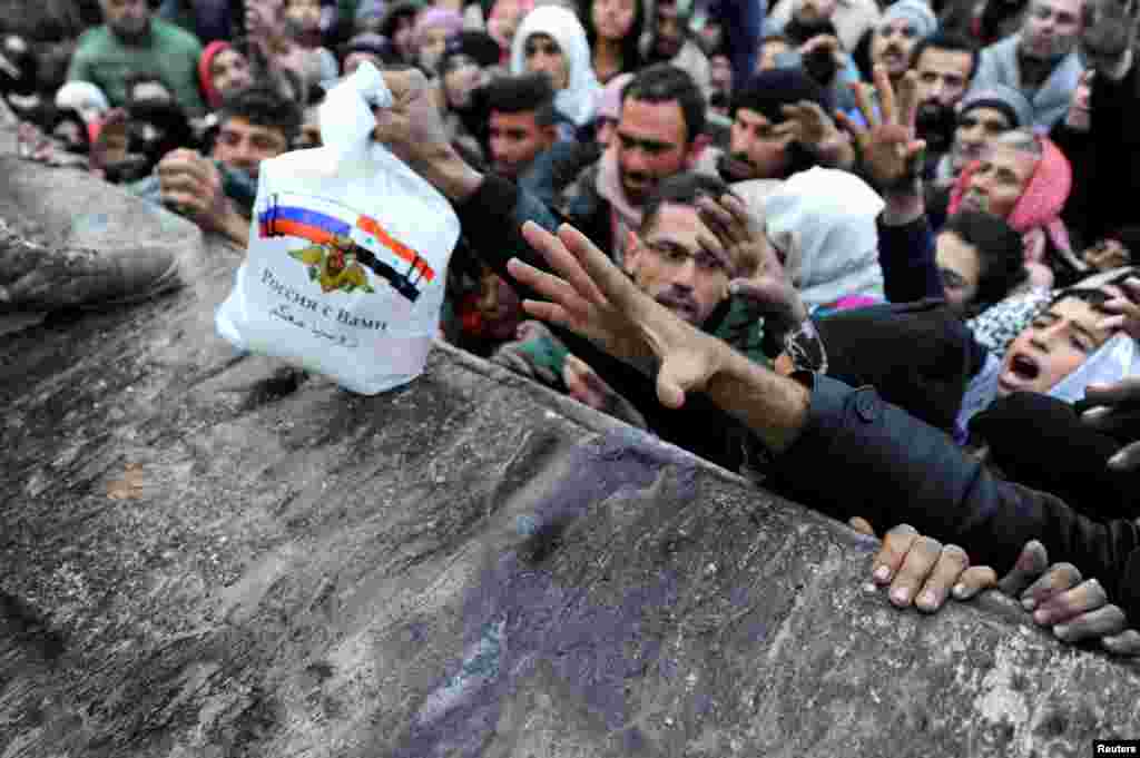 Para pengungsi Suriah yang meninggalkan Aleppo timur, menunggu pembagian makanan dari pasukan Rusia di distrik Jibreen, Aleppo.