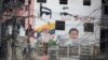 Cables de electricidad cuelgan frente a un edificio con las imágenes borrosas del difunto presidente venezolano Hugo Chávez, a la izquierda, y del actual presidente Nicolás Maduro en el barrio de Petare, en Caracas.