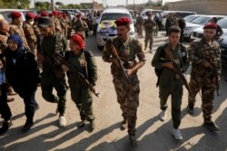 Fighters of Syrian Democratic Forces take part in the funeral procession of Kurdish fighters who were killed during clashes in the northeastern Syrian town of Ras al-Ain, in the town of Qamishli, Syria, Oct. 22, 2019.