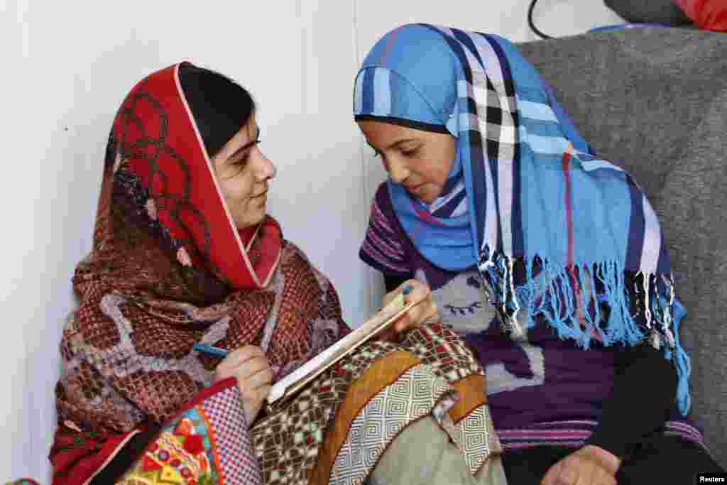Peace Nobelist Malala Yousafzai (left) talks to Syrian refugee Mazoon Rakan, 16, about Mazoon's experience in the camp during her visit to the Zaatri refugee camp, in the Jordanian city of Mafraq, near the border with Syria, Feb. 18, 2014.
