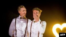 Australian Commonwealth Games sprinter Craig Burns, left, and fiance Luke Sullivan pose ahead of their marriage ceremony at Summergrove Estate, New South Wales, Jan. 8, 2018.