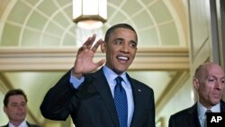 President Barack Obama, escorted by House Sergeant at Arms Paul Irving, right, waves as he arrives on Capitol Hill in Washington, March 13, 2013.
