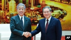 新華社照片: 中國國務院總理李強(右)2024年12月25日星期三在北京人民大會堂會見日本外務大臣岩屋毅。