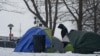Ante escasez de camas y bajas temperaturas, migrantes acampan frente a albergue de Nueva York