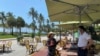 Un mesero del restaurante Il Giardino habla con la dueña del negocio situado en Ocean Drive, una de las zonas más turísticas de Miami Beach, que ha vuelto a abrir tras el brote de coronavirus. 
