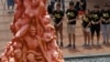FILE - University students place flowers on the "Pillar of Shame" statue, a memorial for those injured and killed in the 1989 Tiananmen Square crackdown, at the University of Hong Kong, June 4, 2018.