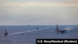 Japan Maritime Self-Defense Force training ships JS Kashima and JS Shimayuki conduct a passing exercise (PASSEX) with Nimitz-class nuclear-powered aircraft carrier USS Ronald Reagan in the South China Sea, July 7, 2020. (U.S. Navy/Handout via REUTERS)