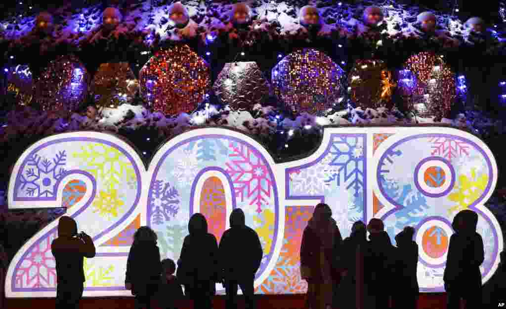 新年将至，白俄罗斯明斯克（Minsk）张灯结彩，人们站在广场上的2018年标志前（2017年12月22日）。