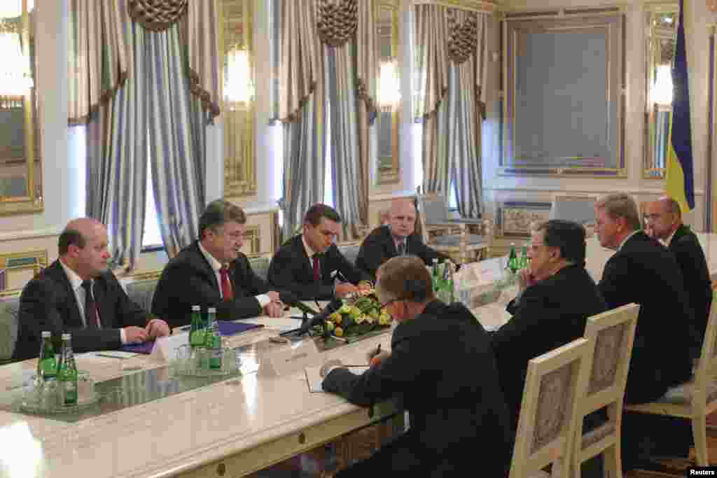 Ukrainian President Petro Poroshenko (2nd left) addresses outgoing European Commission President Jose Manuel Barroso (3rd right) during their meeting in Kyiv, Sept. 12, 2014. 