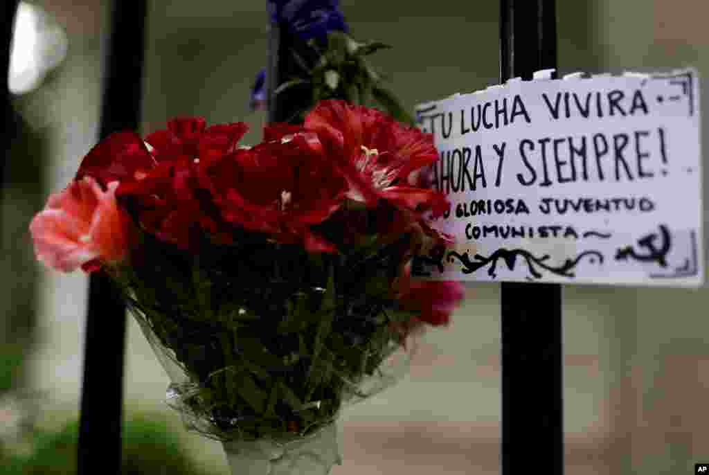 Un ramo de flores para rendirle respeto a Fidel Castro con una pancarta en español "Tu lucha vivirá ahora y siempre" se exhibe fuera de la embajada de Cuba en Buenos Aires, Argentina, el sábado 26 de noviembre de 2016. 