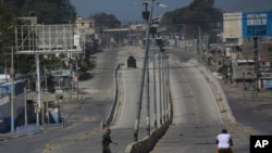 ARCHIVO: Un vehículo blindado circula por una calle principal que está vacía debido a los enfrentamientos entre la policía y las pandillas en el barrio de Delmas, en Puerto Príncipe, Haití, el miércoles 12 de febrero de 2025. (AP Foto/Odelyn Joseph).