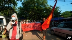 Manifestantes marchan para protestar contra el golpe militar de febrero en Rangún, Myanmar, el domingo 11 de abril de 2021. La pancarta dice: "Absolutamente no dictadura".