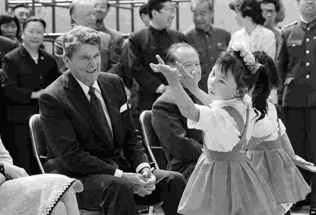 1984年5月1日,美国总统里根在上海郊区虹桥乡幼儿园观看中国女孩表演舞蹈。里根右侧的人似乎是上海市长汪道涵。汪道涵是江泽民的恩师,1962年把江泽民调到上海。1985年汪道涵卸任后,江泽民继任上海市长。美中关系改善,有助于江泽民这样的懂英语也比较善待美国的官员晋升。何清涟在为美国之音撰写的评论中说:“80年代,即中共提拔干部讲究年轻化、知识化、专业化之时,这是学者教授从政最佳的‘天时’。江泽民、胡锦涛及两届中央及省领导就是这样进入政坛的。”