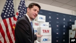 Speaker of the House Paul Ryan, R-Wis., points to boxes of petitions supporting the Republican tax reform bill that is set for a vote later this week as he arrives for a news conference on Capitol Hill in Washington, Nov. 14, 2017. 