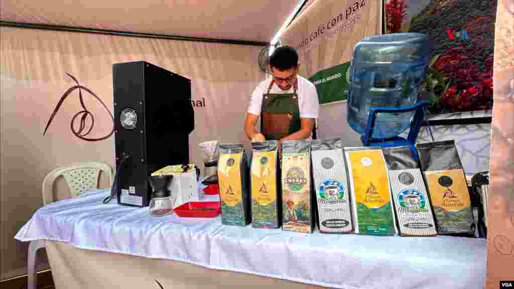 Faiber Trujillo, en una vitrina de exposición con las marcas de café elaboradas en la trilladora del ETCR El Oso en Gaitania, Planadas, Tolima, el 1 de noviembre de 2024. (Foto Javier Hernández / VOA) 