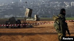 An Israeli soldier stands guard next to an Iron Dome rocket interceptor battery deployed near the northern Israeli city of Haifa, January 28, 2013.