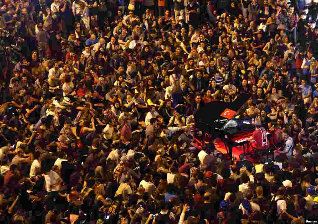 German pianist Davide Martello is surrounded by anti-government protesters as he performs in Istanbul's Taksim Square, June 13, 2013.