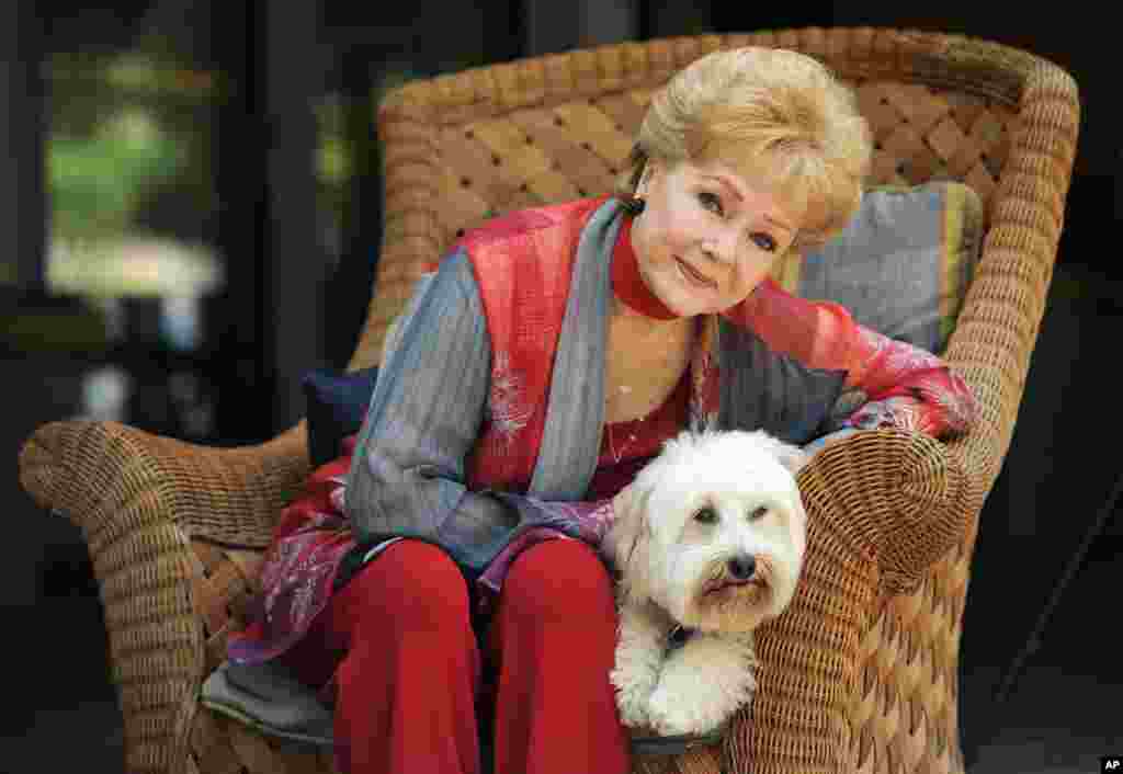 Debbie Reynolds, a cast member in the film "Behind the Candelabra," poses for a portrait with her dog, Dwight, in Beverly Hills, Calif., May 21, 2013. Reynolds plays Frances, the mother of the pianist and vocalist, Liberace.