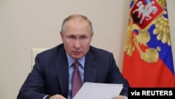 FILE - Russian President Vladimir Putin chairs a meeting with government members via a video conference call at Novo-Ogaryovo state residence outside Moscow, Russia, Feb. 10, 2021.