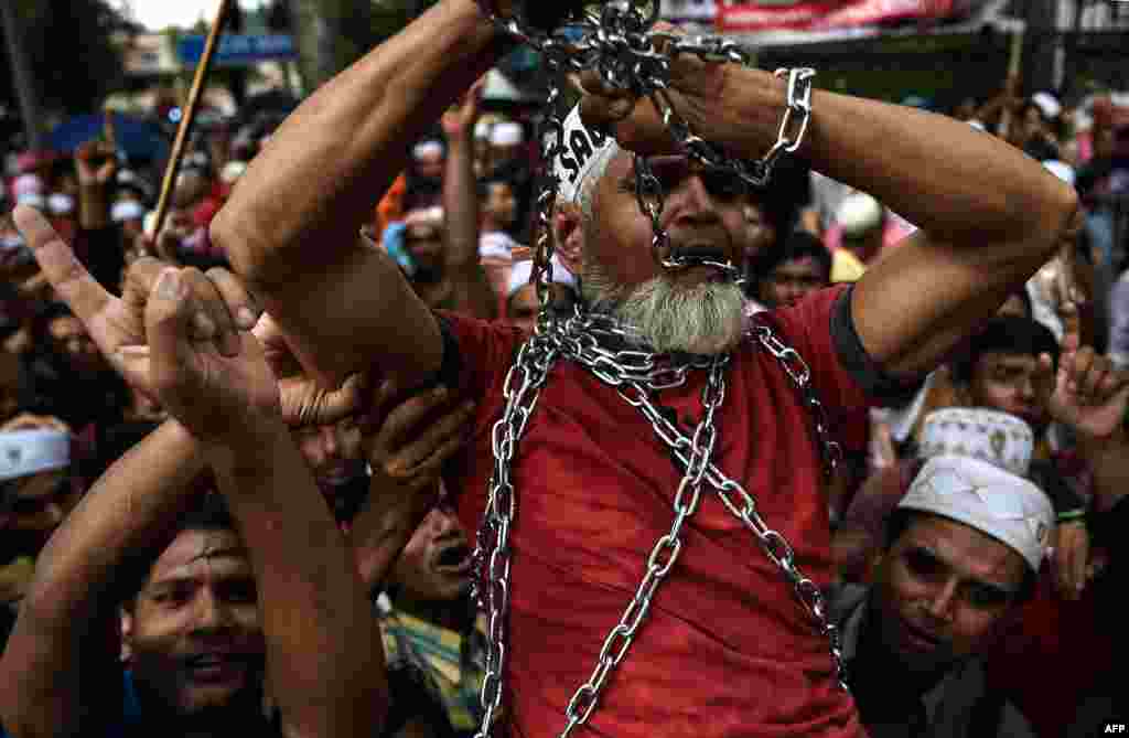 Ethnic Rohingya Muslim refugees shout slogans as they carry a man in chains during a protest against the persecution of Rohingya Muslims in Myanmar, outside the Myanmar Embassy in Kuala Lumpur, Malaysia.