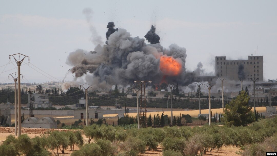 FILE - Smoke and flame rise after what fighters of the Syria Democratic Forces said were U.S.-led airstrikes on the mills of Manbij where Islamic State militants are positioned, in Aleppo Governorate, Syria, June 16, 2016. 