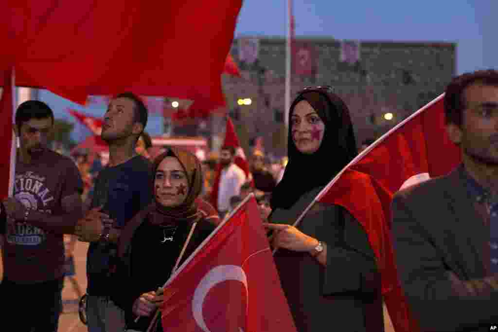 Protesters hold Turkish flags as they gather in Taksim Square in Istanbul, July 17, 2016.