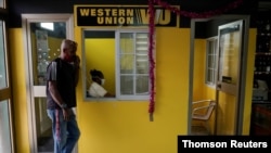 Un hombre habla por teléfono frente a una oficina de Western Union en La Habana.