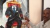 The Somali artist Affey with his painting 'Empty Suit' representing diaspora politicians, Mogadishu, Somalia. (Gabe Joselow/VOA)