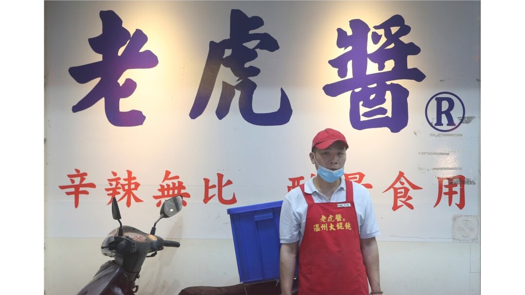 A server wears a face mask outside of a noodle shop in Taipei, Taiwan, on March 3, 2020, to protect against the spread of the coronavirus.