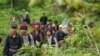 Montagnard hill tribesmen walk towards the main road after emerging from dense forest 70 km (43 miles) northeast of Ban Lung, located in Cambodia's northeastern province of Ratanakiri July 22, 2004. 