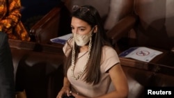 U.S. Rep. Alexandria Ocasio-Cortez (D-NY) talks with colleagues on the floor of the House Chamber as members of congress gathered to take their oath of office during the first session of the 117th Congress on Capitol Hill in Washington, Jan. 3, 2021.