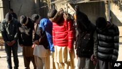 Pakistani suspects allegedly affiliated with the Islamic State group, wait to appear in the anti-terrorist court, in Gujranwala, Pakistan, on Dec. 29, 2015.