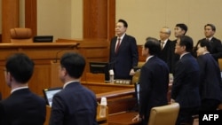(FILE) Presiden Korea Selatan yang dimakzulkan Yoon Suk Yeol (tengah) berdiri saat menghadiri sidang keempat pemakzulannya atas pemberlakuan darurat militer yang berlangsung singkat di Mahkamah Konstitusi di Seoul, 23 Januari 2025. (JEON HEON-KYUN / POOL / AFP)
